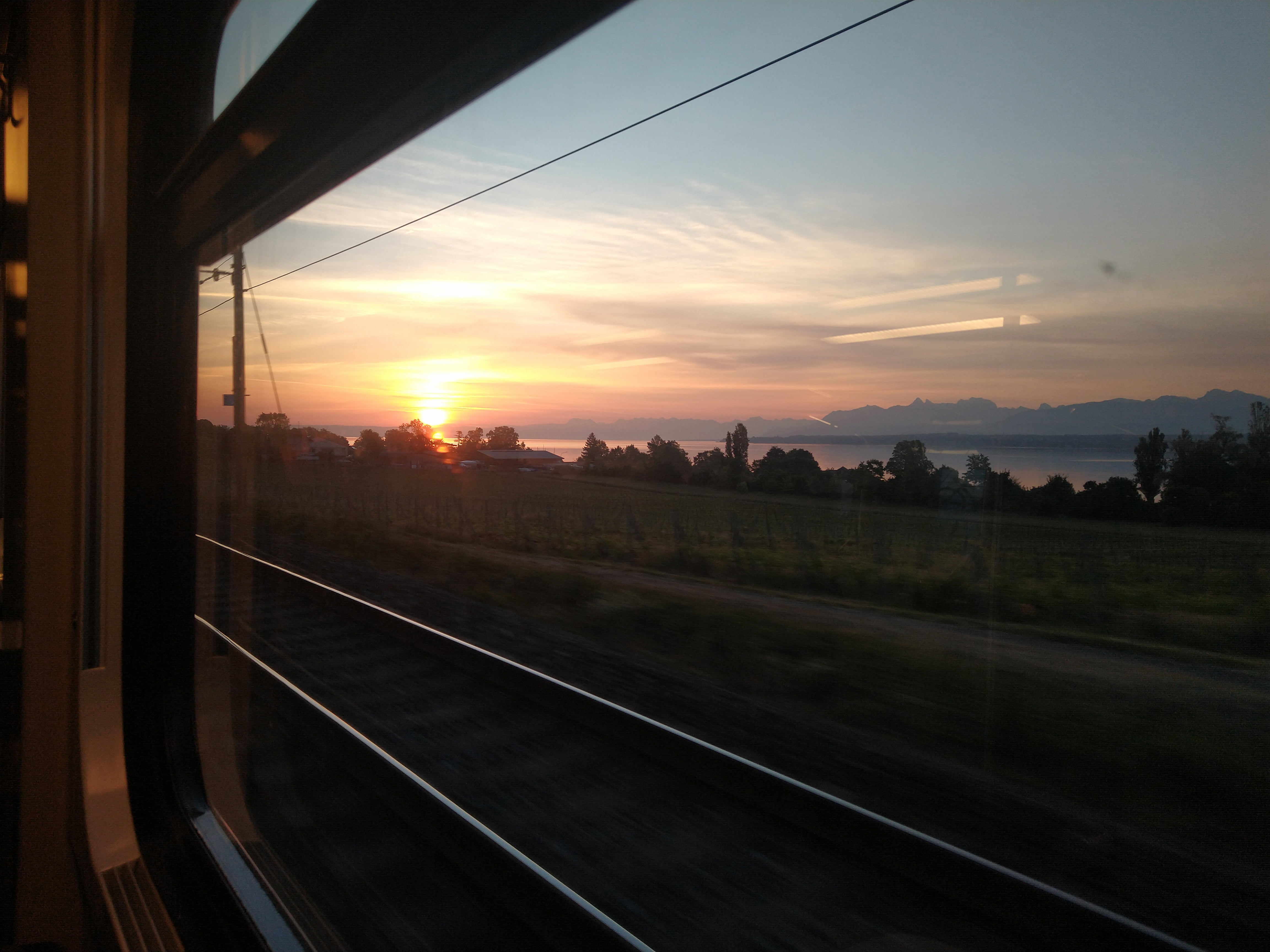 Watching the sunrise over Lac Léman from the train